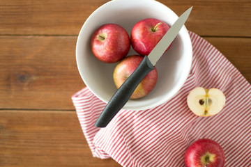 fruits, food cooking and eating concept - apples and kitchen knife on towel