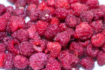Red Raspberries in a square wooden pint container full isolated on white. Red raspberries in a white container. Red raspberry close-up