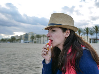 attractive brunette girl eating watermelon by the sea