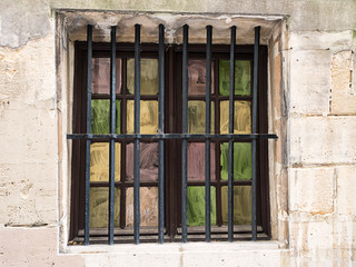 Fototapeta na wymiar Painted and Barred Window in Stone Wall
