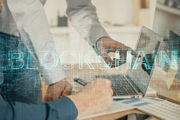 Crypto currency theme hologram with businessman working on computer on background. Concept of blockchain. Multi exposure.