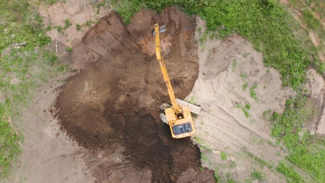 Excavator tractor digger working, aerial top down view