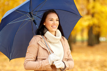 season, weather and people concept - beautiful happy young woman with umbrella in autumn park