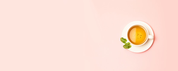 Creative spring concept of white ceramic cup with herbal green or black tea with mint leaves