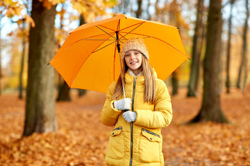 season and weather concept - happy girl with umbrella at autumn park