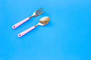 Fork and spoon on blue background.