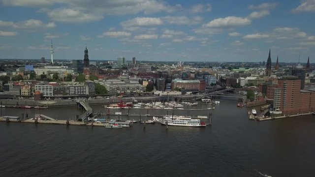 Scenic panorama over the Hamburg harbor with Landungsbruecken, the old harbor district Speicherstadt, ships and boats on river Elbe, and the TV tower with the St. Michaelis church