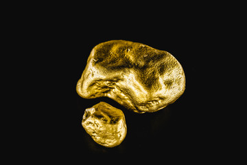Golden stone in high resolution. Gold on black background isolated. Concept of luxury and wealth.