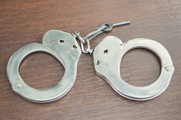 handcuffs and key on wooden table