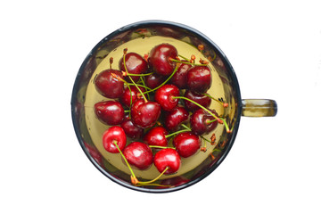 Ripe tasty cherries in a glass cup. Fresh juicy berries against white background. Delicious seasonal fruits. Ripe tasty cherries in a glass cup. Fresh berries