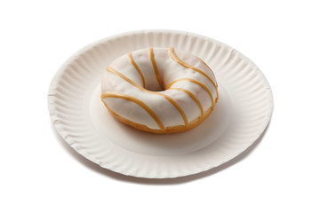 Sweet doghnut in white glaze decorated with sprinkles on a paper plate isolated on a white background