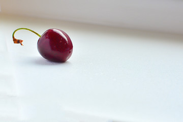 Cherry on a white surface. One cherry on a white surface.