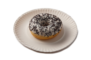Sweet doghnut in white glaze decorated with sprinkles on a paper plate isolated on a white background