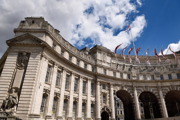 Admiralty Arch building on The Mall dedicated to Queen Victoria with female figure of Navigation and flags at St James's London England