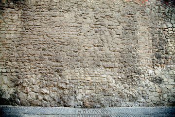 Abstract background of old stone wall and cobblestone pavement. Free space for text and design.