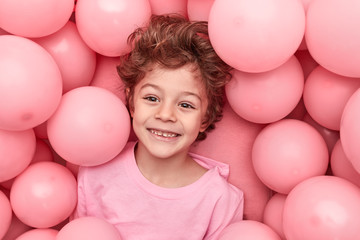 Cheerful boy playing in balloons