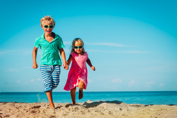 cute happy boy and girl running on beach