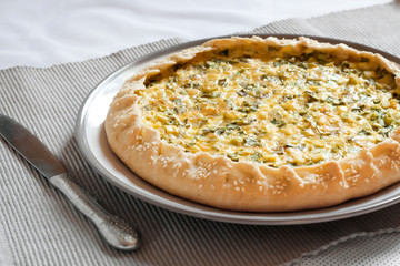Tart with eggs and green onions on a plate