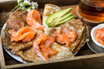 plate of pancakes with salted red fish,black tea for Breakfast on wood tray
