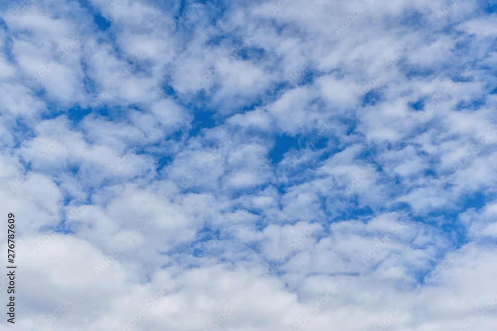 Wall mural light fluffy clouds on a bright blue sky