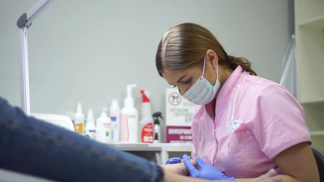 The girl in the center of the hardware pedicure do the procedure.