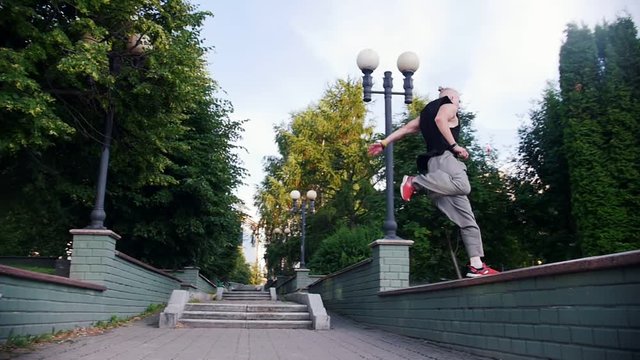 Acrobatic man running up and jumping from one stand to another