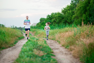 Obraz premium Father and daughter jogging. Cheerful father and daughter run in park together. Sport life concept