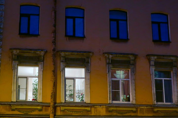Fototapeta na wymiar Lighted windows of an old night residential building