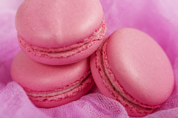 Delicious french dessert. Three gentle soft pastel pink purple cakes  macaron or macaroon on airy fabric,