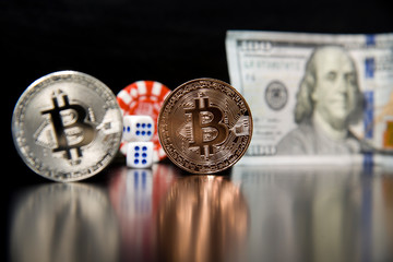 Bitcoin cubes casino chips. Bitcoins on a black background with game cubes.
