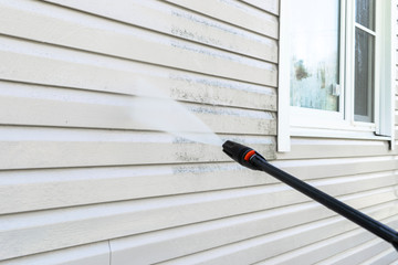 Cleaning service washing building facade with pressure water. Cleaning dirty wall with high pressure water jet. Power washing the wall. Cleaning the facade of the house. Before and after washing