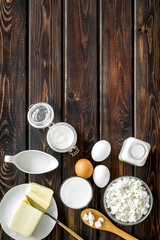 Fresh dairy products for breakfast with milk, cottage, eggs, butter, yougurt on wooden background top view mock up