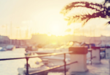 Blurred image of coastline strand with palm trees, sea and cityscape