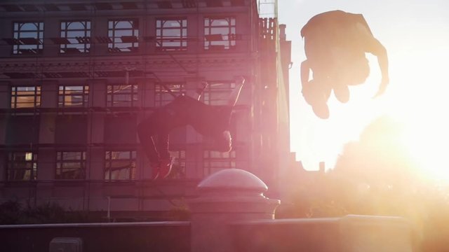 Two acrobatic men jump off the stand - sunset