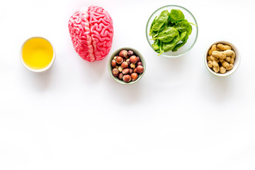 Brain food concept with peanut, hazelnut, seed-oil, spinage on white background top view copyspace