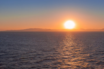 Beautiful sunset over the sea with islands of Saronic Gulf background