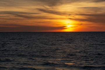 Beautiful fiery sunset sky on the beach. Sunrise over the sea and beautiful cloudscape.