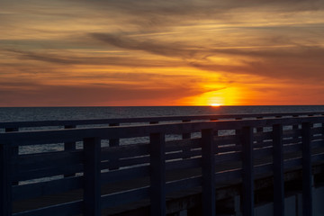 Obraz premium Beautiful fiery sunset sky on the beach. Sunrise over the sea and beautiful cloudscape.