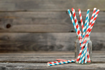 Paper straws in jar on wooden background with copy space - obrazy, fototapety, plakaty