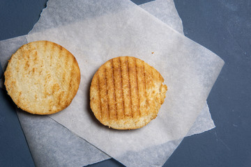 grilled and cut in half burger bun on paper