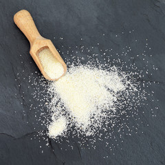 Semolina in wooden scoop, top view