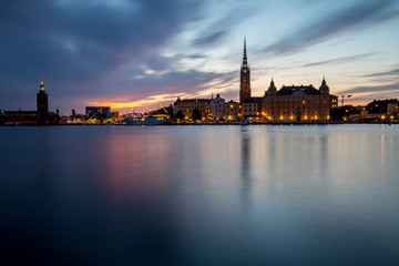 Fototapeta na wymiar Stockholm, panoramic view over the old town and city hall at sunset with city light and boat