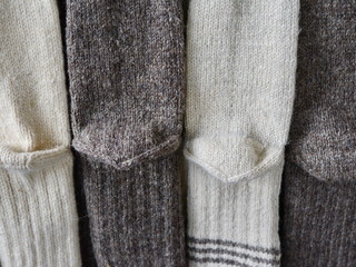 Handmade wool socks hanging for sale on market.