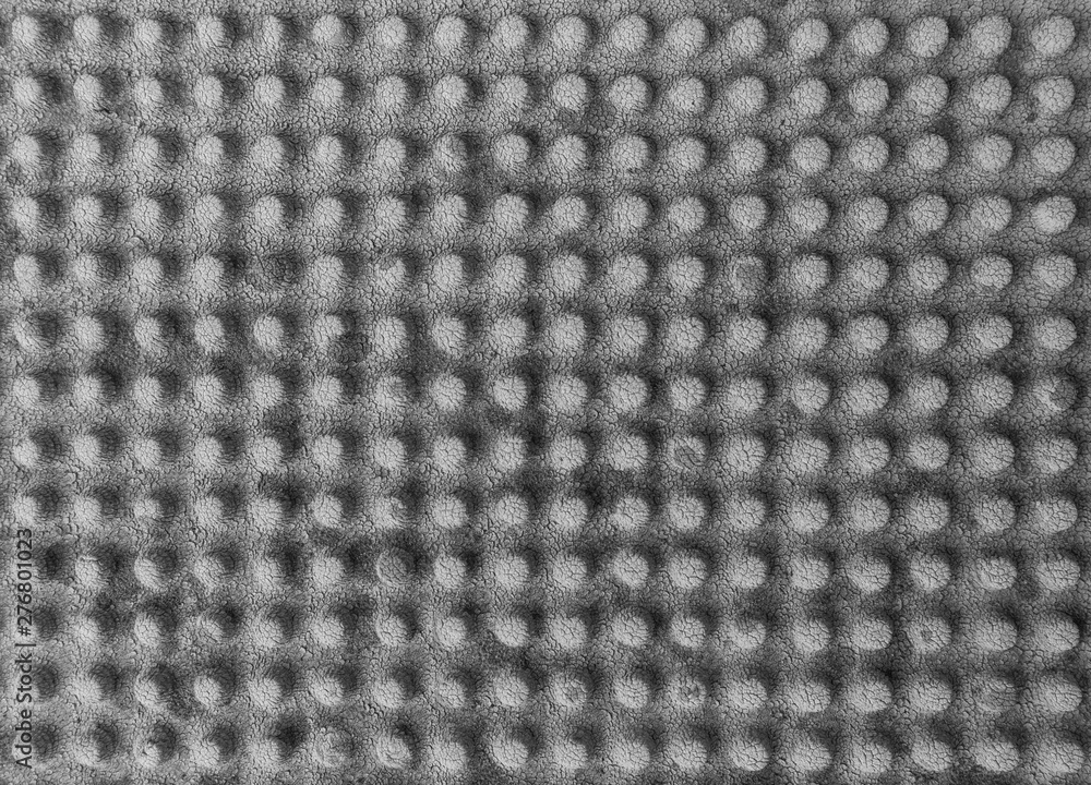 Poster close-up of a weathered and faded rubber mat with knobs in black and white. abstract high resolution
