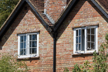 Open sash windows on a classic English country cottage house.
