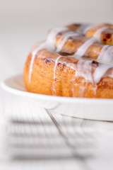 Large gourmet frosted cinnamon roll on white farmhouse table