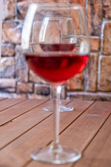 two glasses of red wine on a wooden table