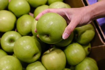 woman chooses apples in the store. counter in apples in a supermarket.