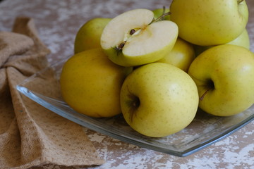 apples on a plate on the table in the kitchen. Chantecler apples.