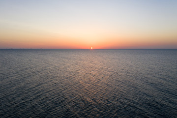 Sea sunrise early morning. Aerial View. Black Sea Sunset. Orange sky and low tide. Sea waves in the rays of a sunset. Sunset on the beach in summer season. Seascape. Sun over the skyline and sea waves